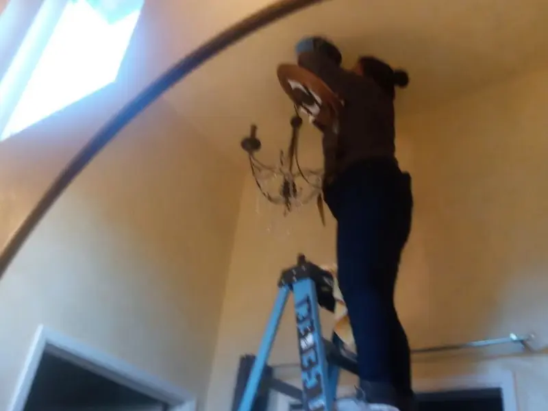 Electrician installing a chandelier in a West Covina residence